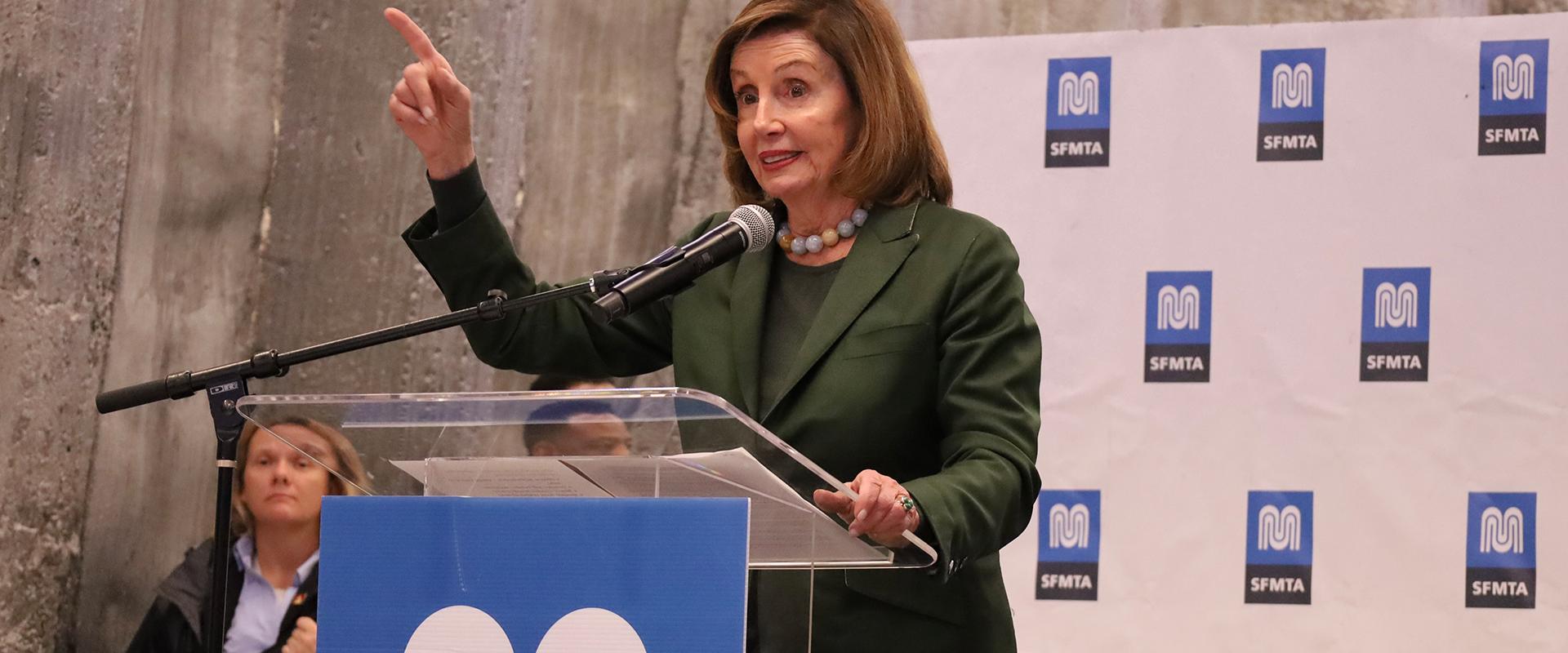 Speaker Pelosi points to the audience at a press conference.